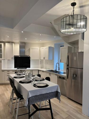 une cuisine avec une table et un réfrigérateur dans l'établissement Grande maison avec beaucoup de charme centre ville de Perpignan, à Perpignan