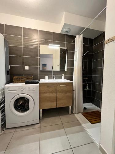 a bathroom with a washing machine and a sink at La Cabane de Mimizland ~ 10 min à pied de l'océan in Mimizan