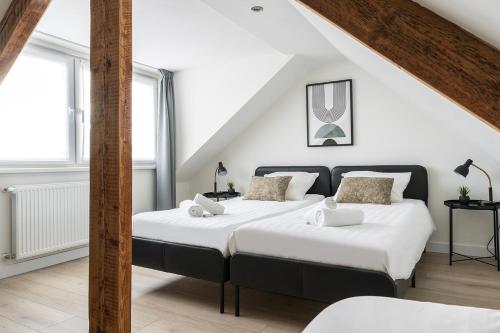 two beds in a room with white walls at 6p newly renovated home with unique roof-terrace in Strijp