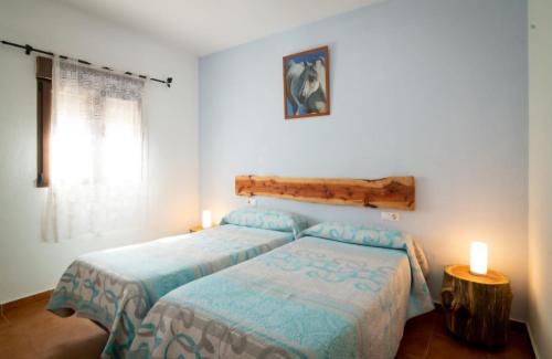 a bedroom with two beds and two candles in it at Casa Papi in Zafrilla