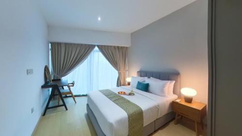 a bedroom with a large white bed and a window at Eaton Residence KLCC - KL SUITE in Kuala Lumpur