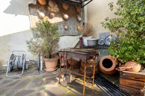 a patio with a grill with plants and pots at 4Season Villa in Tbilisi City