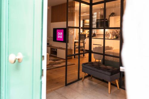 a living room with a tv and a chair in a room at La Chicca in pieno centro storico con SAUNA e Parcheggio gratuito in Udine