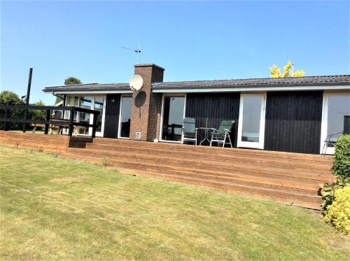 a house with a wooden deck in the yard at Awesome Home In Rønde With 3 Bedrooms in Rønde