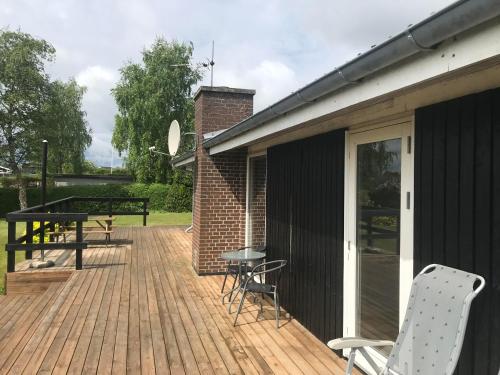 a wooden deck with chairs and a table on it at Awesome Home In Rønde With 3 Bedrooms in Rønde