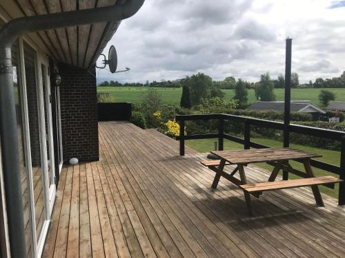 a wooden deck with a picnic table on a house at Awesome Home In Rønde With 3 Bedrooms in Rønde