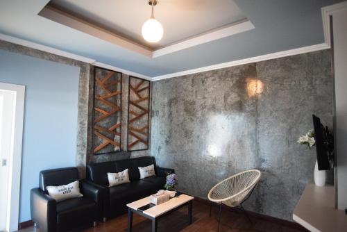 a living room with a couch and a table at The Proud Hotel in Ubon Ratchathani