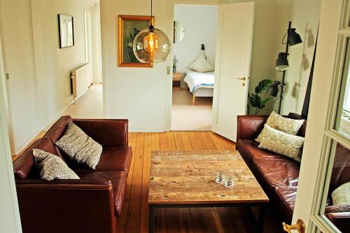 a living room with a couch and a coffee table at Amazing Home In Rudkøbing With 6 Bedrooms And Wifi in Spodsbjerg