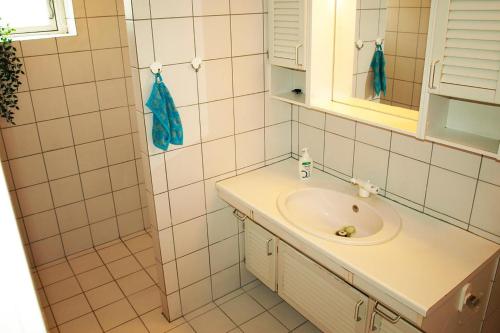 a bathroom with a sink and a mirror at Amazing Home In Rudkøbing With 6 Bedrooms And Wifi in Spodsbjerg