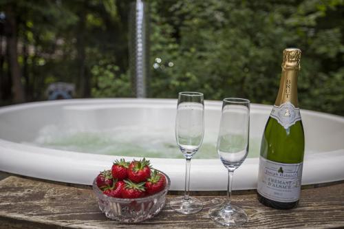two wine glasses and a bottle of champagne and a bowl of strawberries at Holiday Home With A Wilderness Bath, Only 100 Meters From The Lovely Beach in Marielyst