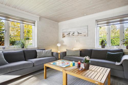 a living room with couches and a coffee table at Holiday Home With A Wilderness Bath, Only 100 Meters From The Lovely Beach in Marielyst