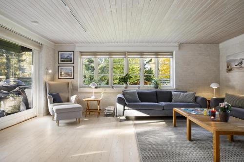 a living room with a couch and a table at Holiday Home With A Wilderness Bath, Only 100 Meters From The Lovely Beach in Marielyst