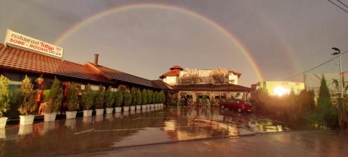 a rainbow in the sky over a building at Hotel Talija in Svilajnac