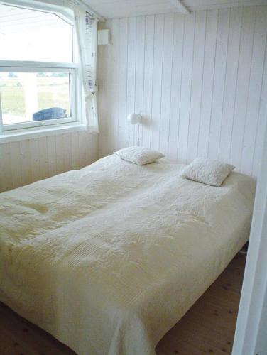 une chambre avec un grand lit blanc avec une fenêtre dans l'établissement Nice Home In Rudkøbing With 3 Bedrooms, Sauna And Wifi, à Spodsbjerg