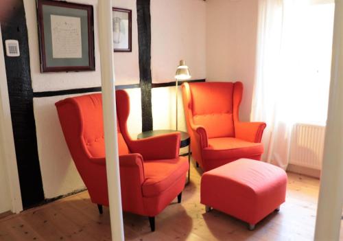 two orange chairs and a stool in a room at Amazing Home In Höganäs With 2 Bedrooms And Wifi in Höganäs