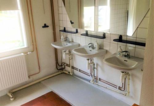 a bathroom with three sinks and a mirror at Beautiful Home In Torup With 13 Bedrooms in Torup