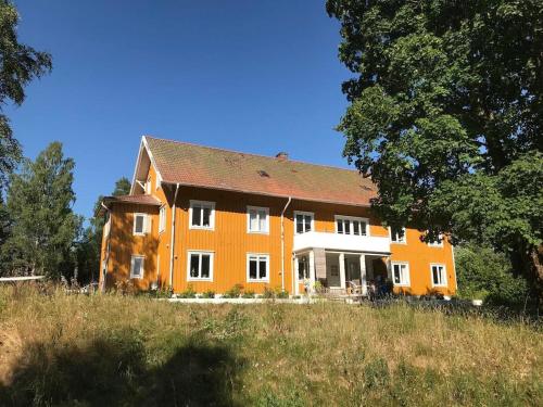 an orange and white house on a hill with trees at Beautiful Home In Torup With 13 Bedrooms in Torup
