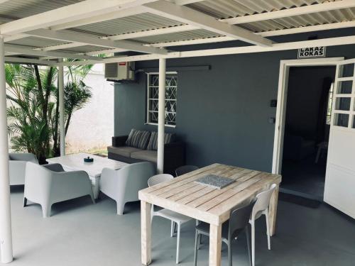 eine Terrasse mit einem Tisch, Stühlen und einem Sofa in der Unterkunft Lakaz Kokas in Pereybere