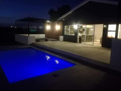 a house with a swimming pool at night at Addo Park Suma's Rest in Addo