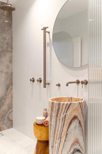 a bathroom with a wooden sink and a mirror at Belles Bondi Beach Apartments - 1 and 2 Bedroom Stays - 500m to beach in Sydney