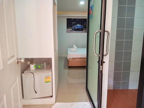 a small room with a refrigerator and a bedroom at เกาะช้างรักดี รีสอร์ท in Ko Chang