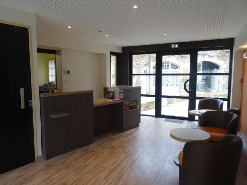 an office with a desk and chairs and a table at Hotel - Restaurant Les 3 Piliers in Le Boupère