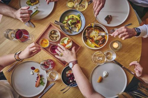 a group of people sitting around a table eating food at Hotel Balga Natur- und Bikehotel in Balgach