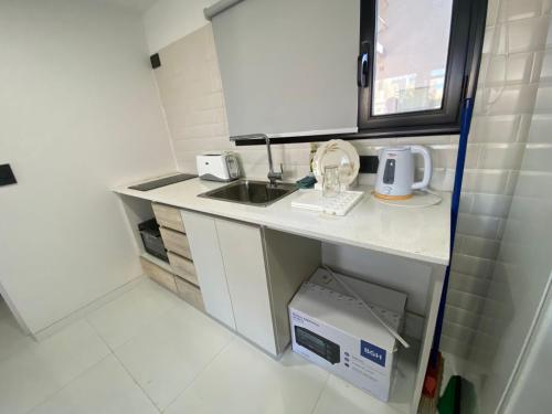 a small kitchen with a sink and a microwave at Eleganza in Neuquén