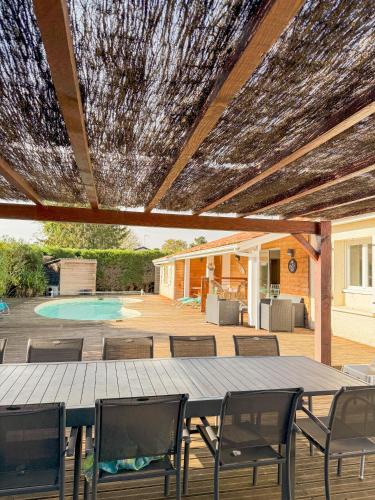 un patio avec une table et des chaises et une piscine dans l'établissement Villa Familiale avec Piscine Privée, à Toulenne