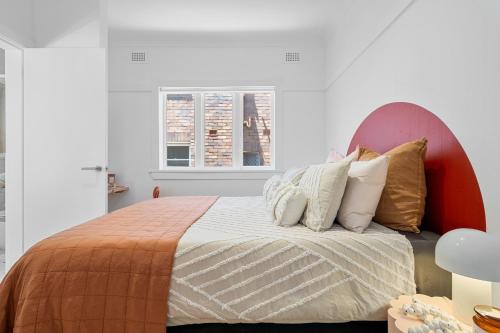 a bedroom with a bed with pillows on it at Belles Bondi Beach Apartments - 1 and 2 Bedroom Stays - 500m to beach in Sydney