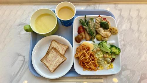 a tray with a meal of pasta and vegetables and toast at Toyoko Inn Tottori-eki Kita-guchi in Tottori