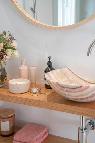 a bathroom shelf with a sink and a mirror at Belles Bondi Beach Apartments - 1 and 2 Bedroom Stays - 500m to beach in Sydney