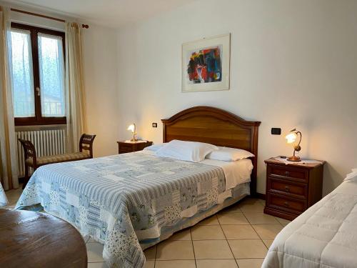 a bedroom with a bed and two tables and two lamps at Al Vajo in Lazise