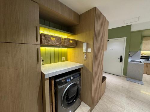 a kitchen with a washing machine in a kitchen at Podomoro City Deli Medan Tower Empire - Japandi Style - 2BR Family Suite 3 beds - 87m in Medan