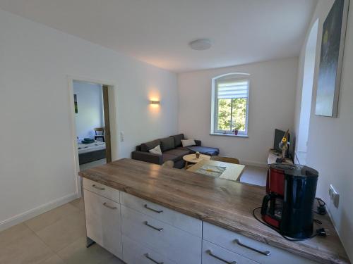 a kitchen with a counter top and a living room at Ferienwohnung "EDDI" in Hohnstein
