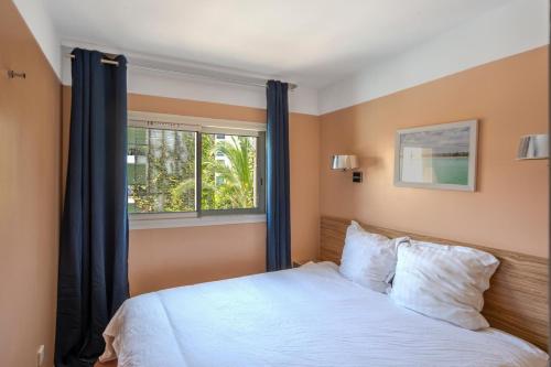 une chambre avec un lit blanc et une fenêtre dans l'établissement MISTRAL-Rare 6 pers, parking, wifi, ,clim, piscines, à Antibes