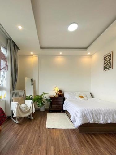 a bedroom with a large bed and a chair at Nai Homestay 2 in Da Thanh