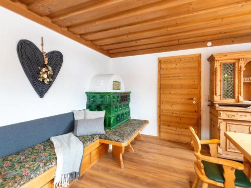 a living room with a blue couch and a green stove at Farmhouse in Bramberg with Sauna & Ski Access in Dorf