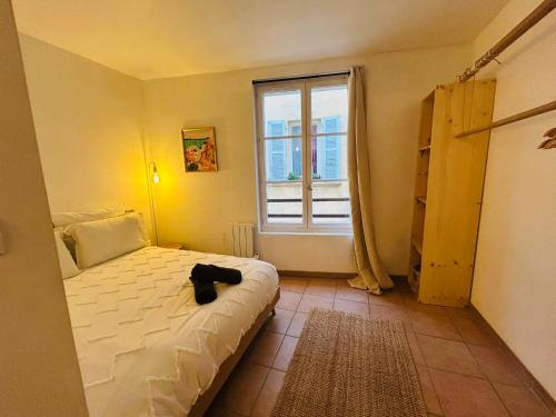 une chambre avec un lit et une fenêtre dans l'établissement Chez Max charmant appartement 2 chambres au cœur du Panier proche Vieux Port, à Marseille