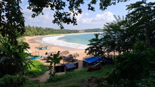 a view of a beach with a house and the ocean at Talalla Wonder View in Talalla South