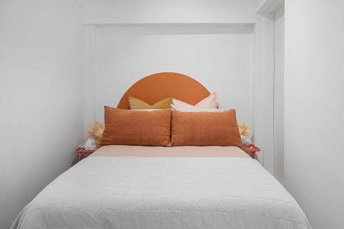 a bed with an orange headboard in a room at Belles Bondi Beach Apartments - 1 and 2 Bedroom Stays - 500m to beach in Sydney