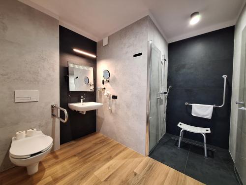 a bathroom with a toilet and a sink and a shower at Hotel Gromada Łomża in Łomża