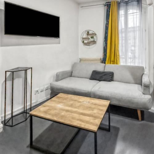 un salon avec un canapé et une table dans l'établissement Espace familial proche de Paris, à La Courneuve