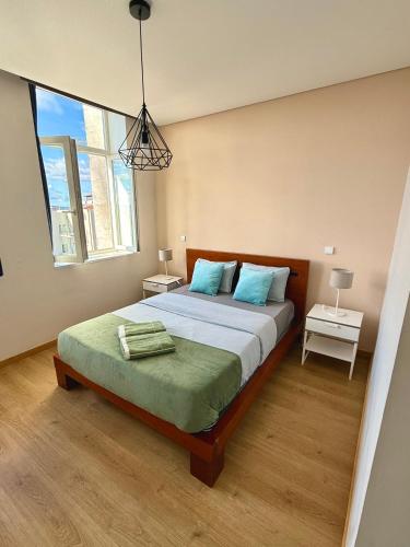 a bedroom with a large bed with blue pillows at Âmbar Guest House in Braga
