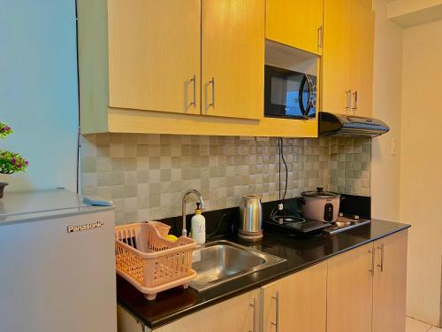 a kitchen with a sink and a refrigerator at SMDC Wind Residences Tower 4 Taal view in Tagaytay
