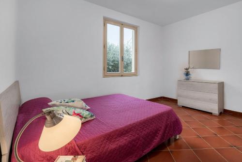 a bedroom with a purple bed with a lamp on it at Borgo House In Florentine Hills With Pool in Fucecchio