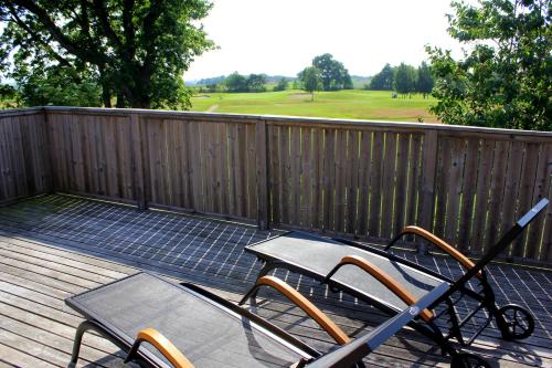 a deck with a table and chairs on a fence at Åkagårdens Lodge in Båstad