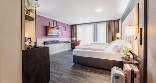 a hotel room with two beds and a tv at PLAZA Premium Heidelberg in Heidelberg