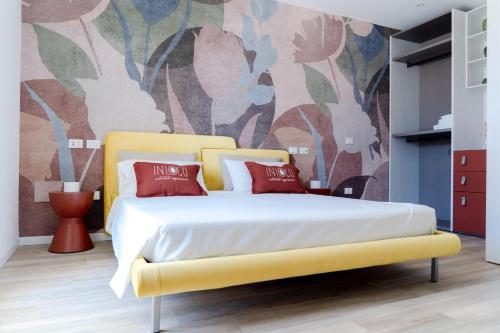 a bedroom with a yellow bed with red pillows at InLoco - Natural Experience in Acqualagna