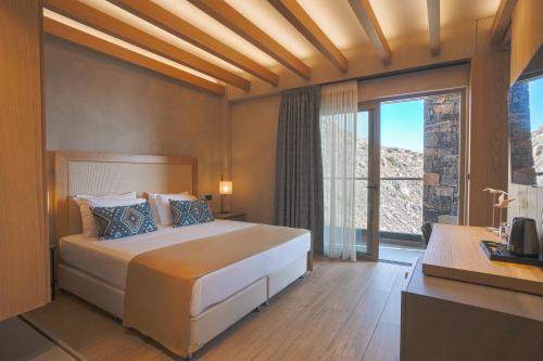a bedroom with a large bed and a large window at panorama new generation in Sfakia